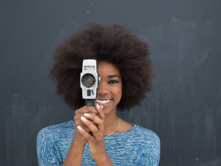 Image showing african american woman using a retro video camera