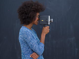 Image showing african american woman using a retro video camera