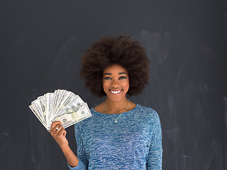 Image showing black woman holding money on gray background