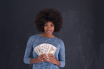 Image showing black woman holding money on gray background