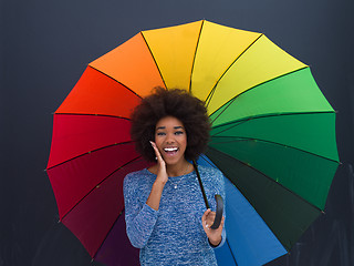 Image showing african american woman holding a colorful umbrella