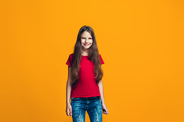 Image showing The happy teen girl pointing to you, half length closeup portrait on orange background.