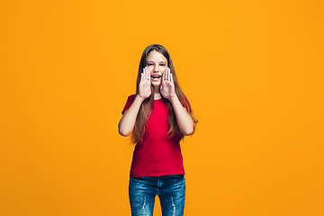 Image showing Isolated on yellow young casual teen girl shouting at studio