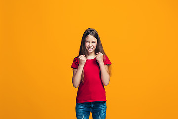 Image showing Portrait of angry teen girl on a orange studio background