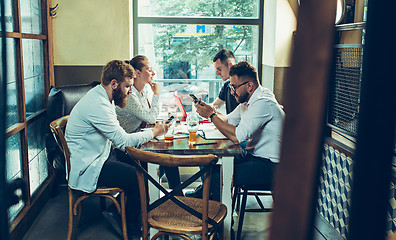 Image showing Young cheerful people smile and gesture while relaxing in pub.