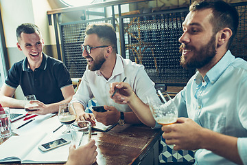 Image showing Young cheerful people smile and gesture while relaxing in pub.