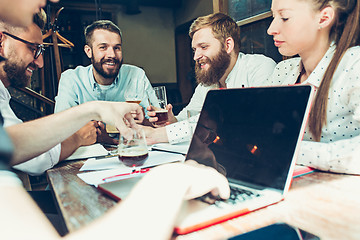 Image showing Young cheerful people smile and gesture while relaxing in pub.