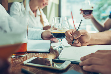 Image showing Young cheerful people smile and gesture while relaxing in pub.