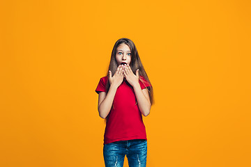 Image showing Beautiful teen girl looking suprised isolated on orange