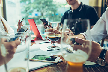 Image showing Young cheerful people smile and gesture while relaxing in pub.