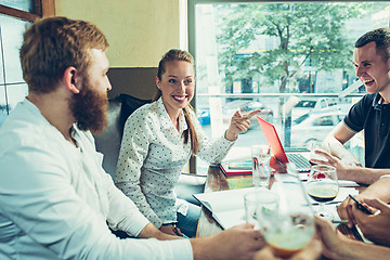 Image showing Young cheerful people smile and gesture while relaxing in pub.