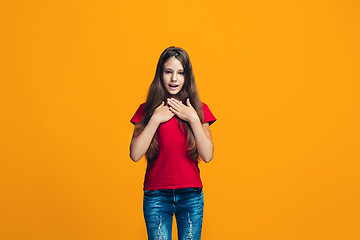 Image showing Beautiful teen girl looking suprised isolated on orange