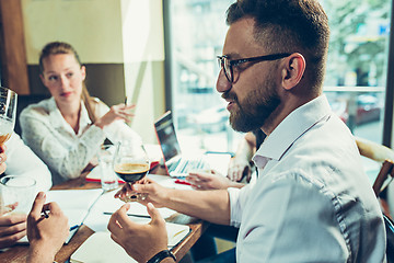 Image showing Young cheerful people smile and gesture while relaxing in pub.