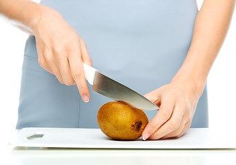 Image showing Cook is chopping kiwi fruit