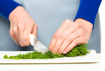 Image showing Cook is chopping green dill