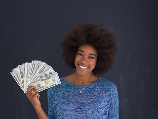 Image showing black woman holding money on gray background