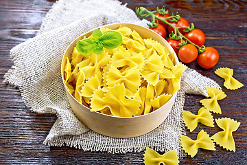 Image showing Farfalle in bark box with basil on board