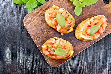 Image showing Bruschetta with tomato and basil on board top