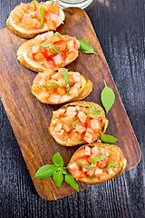 Image showing Bruschetta with tomato and basil on dark board top