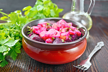 Image showing Salad of beets and potatoes with oil in bowl on dark board