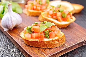 Image showing Bruschetta with tomato and spinach on board