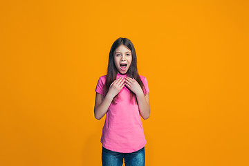 Image showing Beautiful teen girl looking suprised isolated on orange