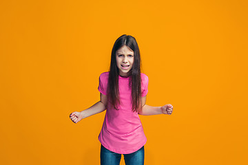 Image showing Portrait of angry teen girl on a orange studio background