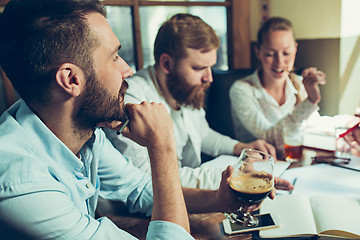 Image showing Young cheerful people smile and gesture while relaxing in pub.