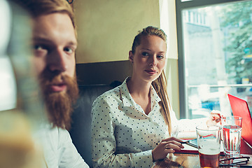 Image showing Young cheerful people smile and gesture while relaxing in pub.