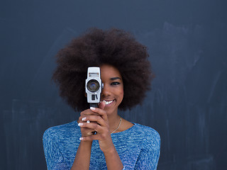 Image showing african american woman using a retro video camera