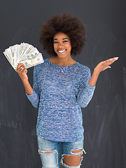 Image showing black woman holding money on gray background