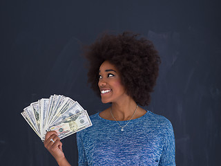 Image showing black woman holding money on gray background