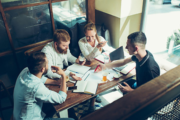 Image showing Young cheerful people smile and gesture while relaxing in pub.