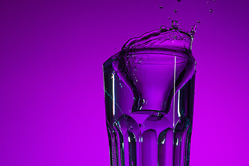 Image showing The water splashing in glass on lilac background