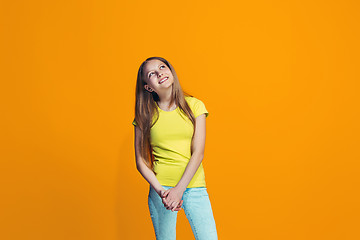 Image showing The happy teen girl standing and smiling against pink background.