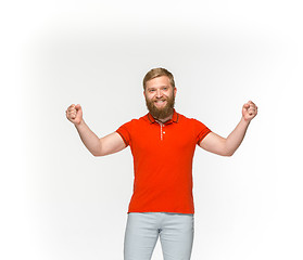 Image showing Closeup of young man\'s body in empty red t-shirt isolated on white background. Mock up for disign concept