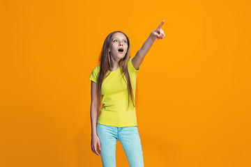 Image showing Beautiful teen girl looking suprised isolated on orange