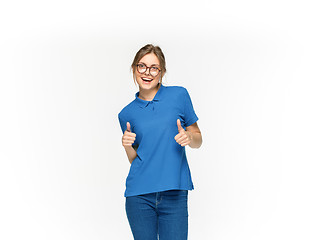 Image showing Closeup of young woman\'s body in empty blue t-shirt isolated on white background. Mock up for disign concept