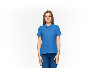 Image showing Closeup of young woman\'s body in empty blue t-shirt isolated on white background. Mock up for disign concept