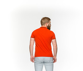 Image showing Closeup of young man\'s body in empty red t-shirt isolated on white background. Mock up for disign concept