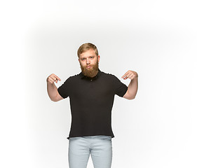 Image showing Closeup of young man\'s body in empty black t-shirt isolated on white background. Mock up for disign concept