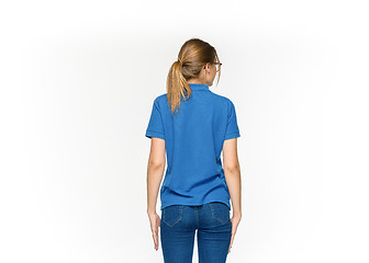 Image showing Closeup of young woman\'s body in empty blue t-shirt isolated on white background. Mock up for disign concept