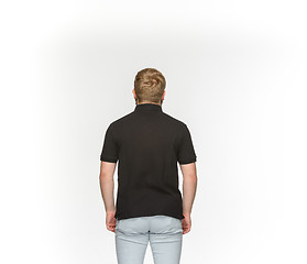 Image showing Closeup of young man\'s body in empty black t-shirt isolated on white background. Mock up for disign concept