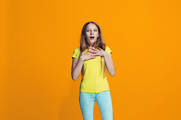 Image showing Beautiful teen girl looking suprised isolated on orange