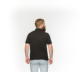 Image showing Closeup of young man\'s body in empty black t-shirt isolated on white background. Mock up for disign concept