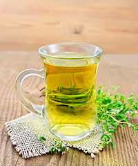 Image showing Tea of thyme in mug on wooden board