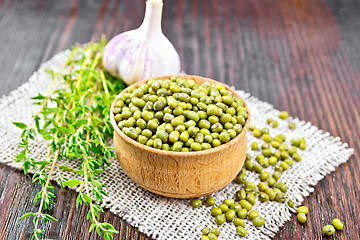 Image showing Mung beans in wooden bowl with thyme on table