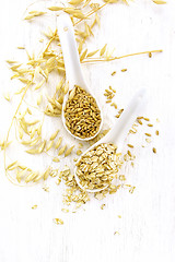 Image showing Oat flakes and grains in spoons on board top