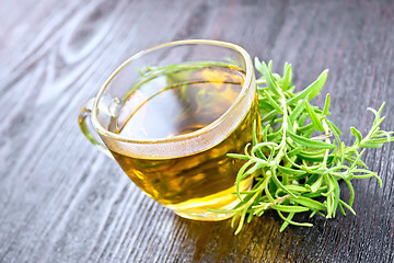 Image showing Tea of rosemary in cup on wooden board