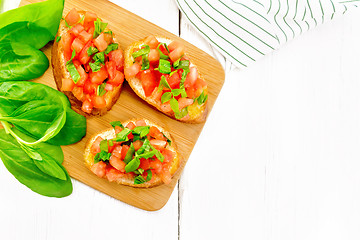 Image showing Bruschetta with tomato and spinach on light board top